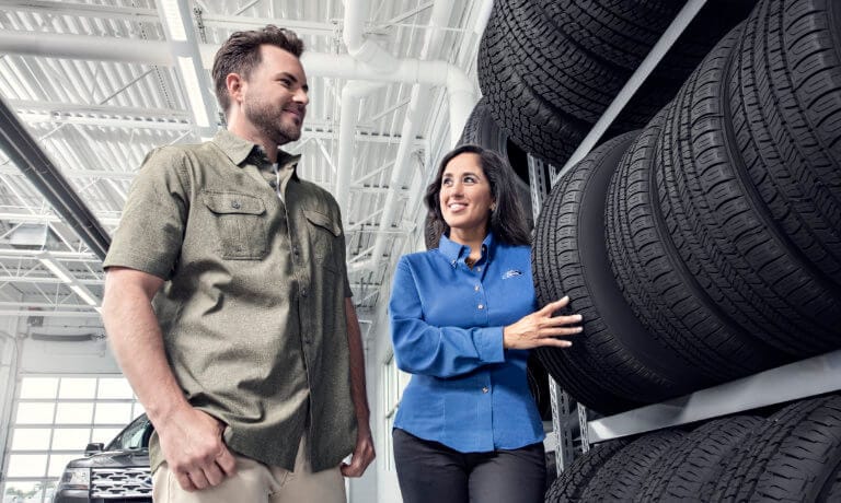 image of a woman showing tires to a man